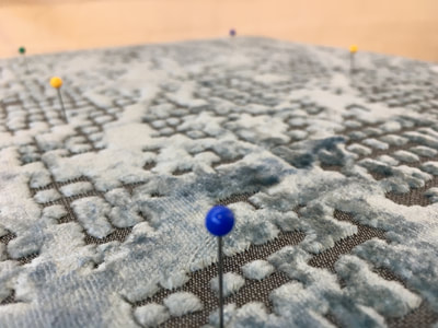 Pins marking button locations on small footstool