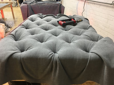 Large grey deep buttoned footstool in progress