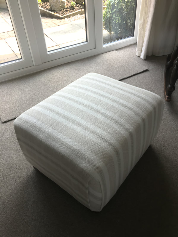 Reupholstered footstool with striped fabric